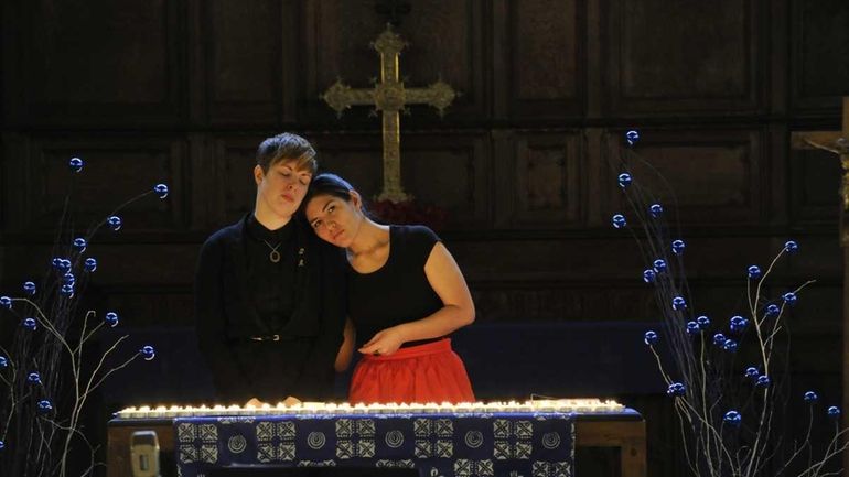 Sarah Elspeth Patterson, left, and Kate D'Adamo light candles to...