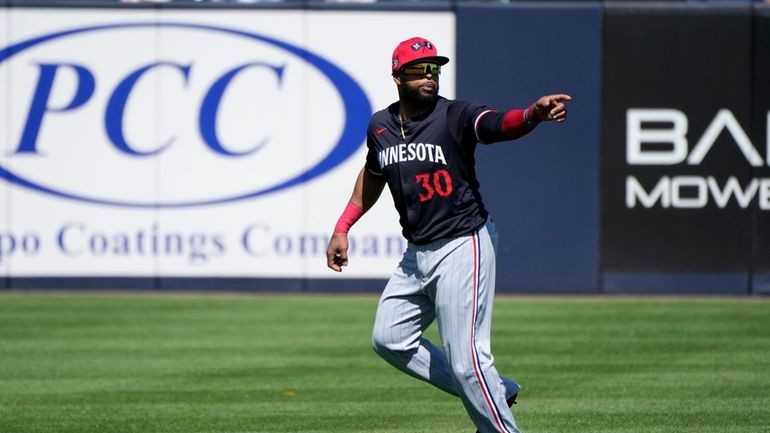 Minnesota Twins first baseman Carlos Santana runs on the field...