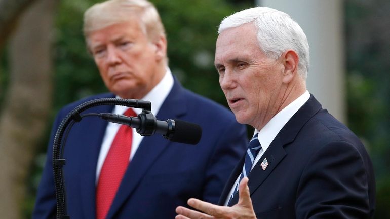 President Donald Trump listens as Vice President Mike Pence speaks...