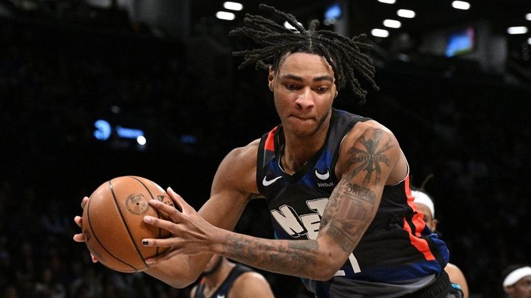 Nets forward Noah Clowney reaches for the ball along the...