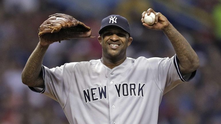 Yankees starting pitcher CC Sabathia reacts after giving up three...