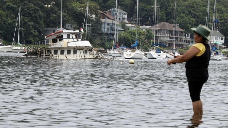 The Noli Eileen, a 56-foot fishing boat, is partially submerged...