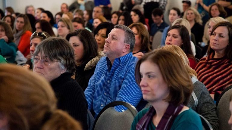 Wayne Wellinger, 49, of St. James, listens to speakers during...