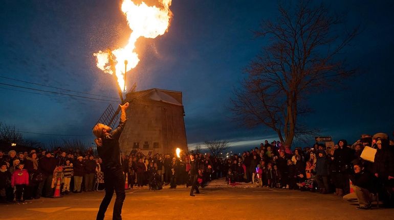 A juggler performs a fire stunt in front of spectators...