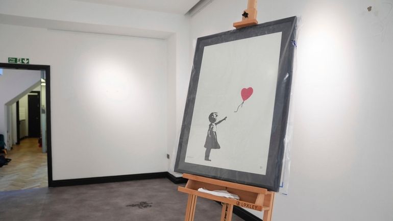 A Banksy painting, Girl With Balloon, on display at the...