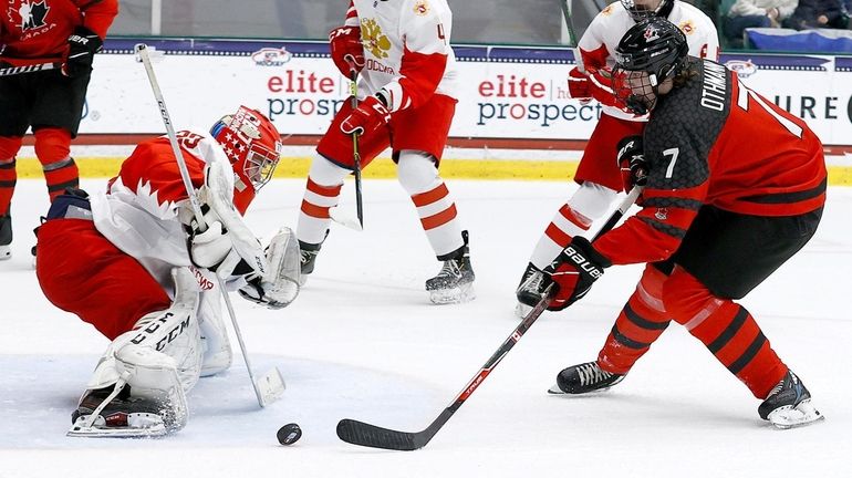 Brennan Othmann of Canada puts a shot on goal against Sergei...