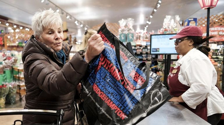 Carol Kolakowski of Melville, being rung up by cashier Staci Snowden...