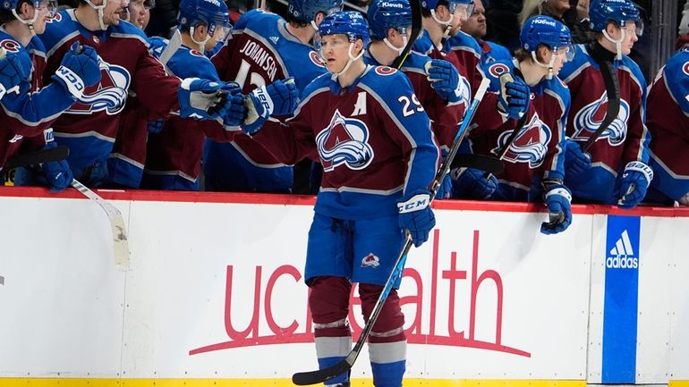 Colorado Avalanche center Nathan MacKinnon, front, is congratulated as he...