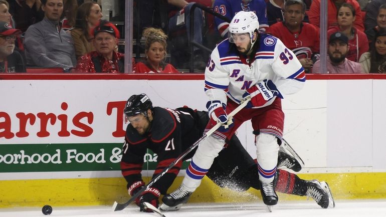 Mika Zibanejad of the Rangers gets the puck past Barclay Goodrow of...