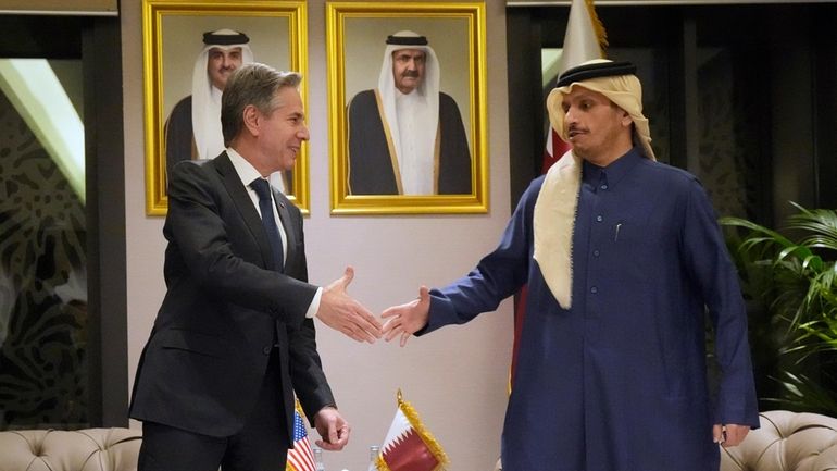 US Secretary of State Antony Blinken, left, shakes hands with...