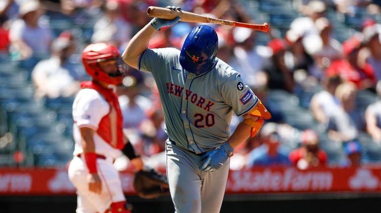 Pete Alonso #20 of the New York Mets throws his...