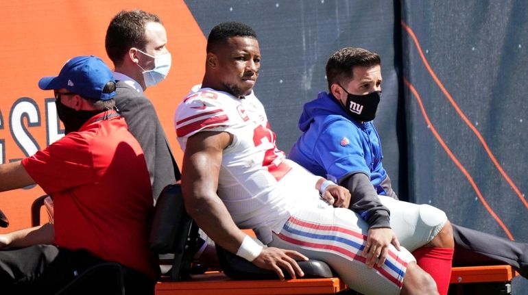Giants running back Saquon Barkley is carted to the locker room...