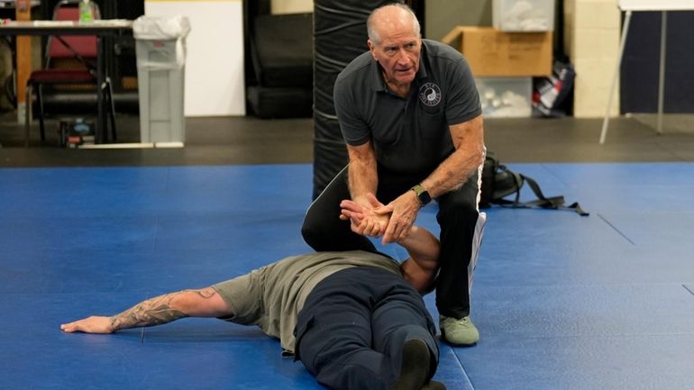 Instructor Dave Rose demonstrates a prone handcuffing position on a...