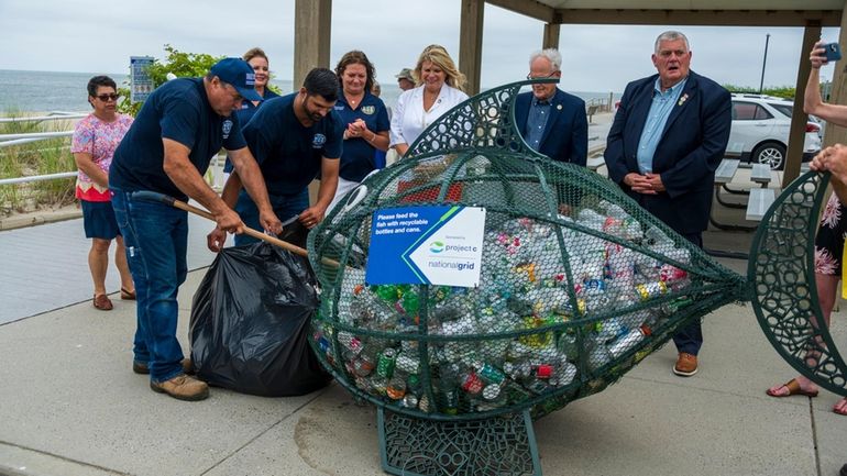 Town employees empty the fish receptacle at Iron Pier Beach in...