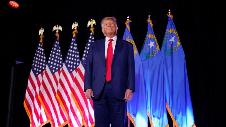 Former President Donald Trump stands on stage before speaking at...