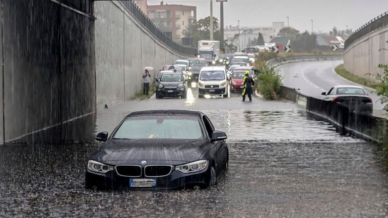 Cars are blocked in flooded streets in Milan, northern Italy,...