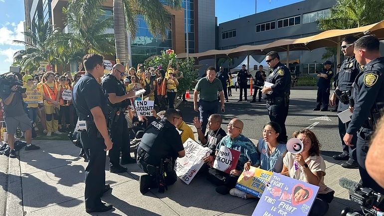 In this photo provided by Ashley Young, Honolulu police officers...