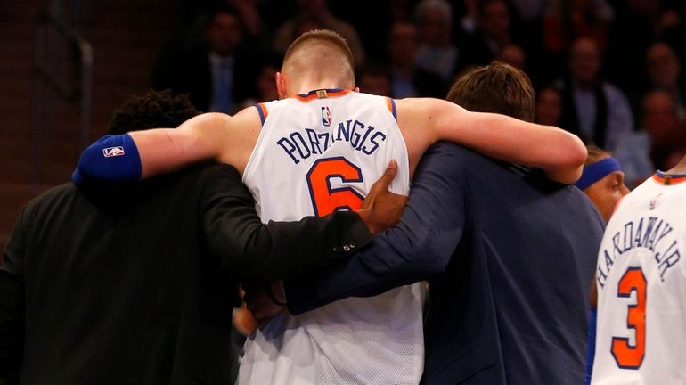 Kristaps Porzingis of the Knicks is helped off the court...