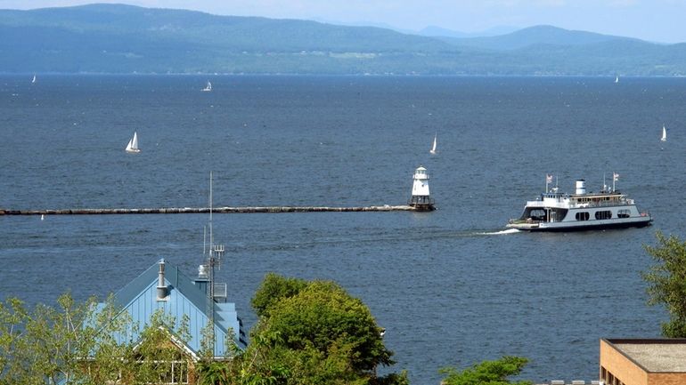 Sailboats and a passenger ferry dot Lake Champlain as seen...