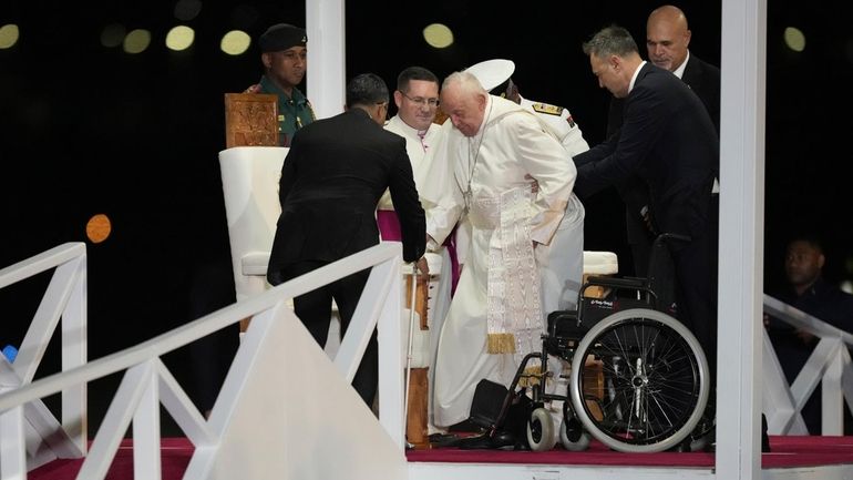 Pope Francis is helped down a ramp at Jackson's International...