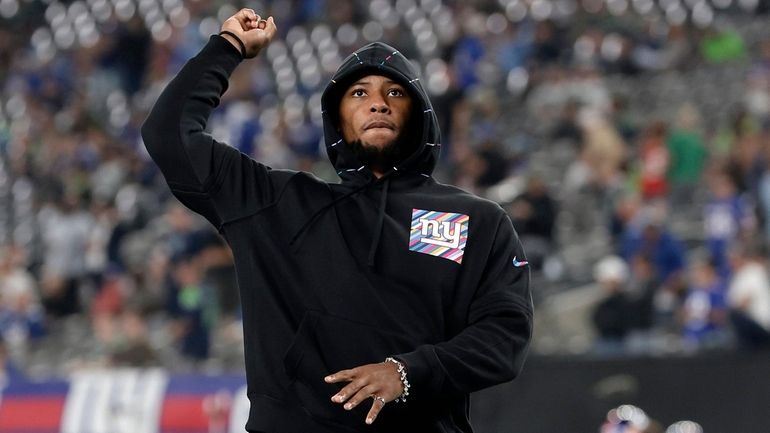 Saquon Barkley of the Giants stands on the field before a game...