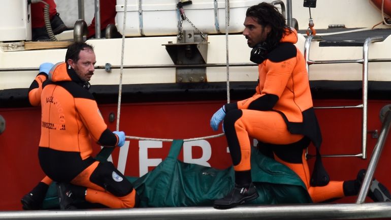 Italian Firefighters scuba divers bring ashore in a green bag...