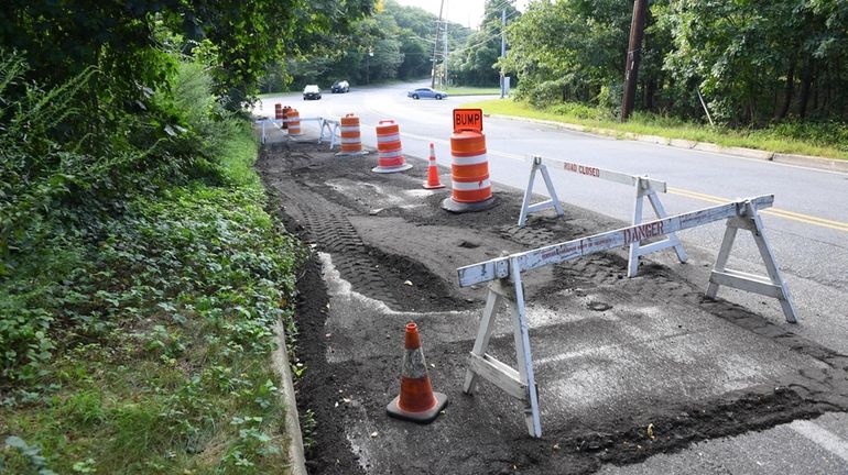 Barriers block off flood damage Wednesday on Old Northport Road and...