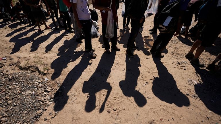 Migrants wait to be processed by the U.S. Customs and...