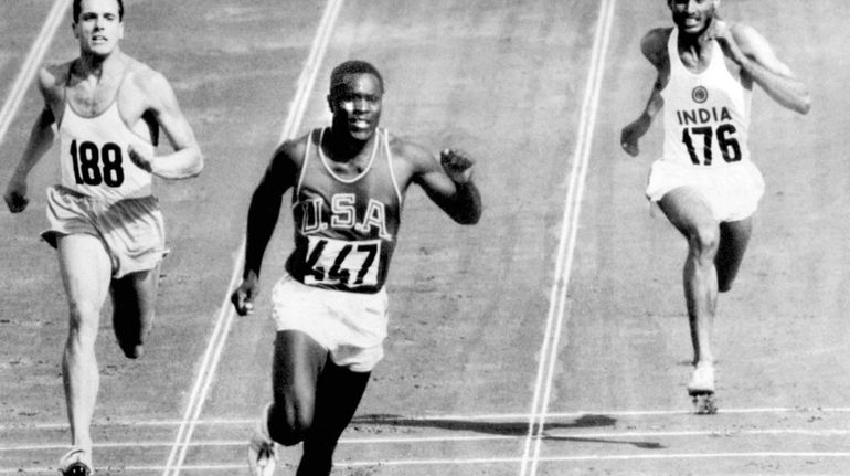 Rafer Johnson of the United States, center, finishes the fourth...