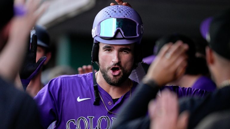 Colorado Rockies' Sam Hilliard, center, celebrates with teammates in the...