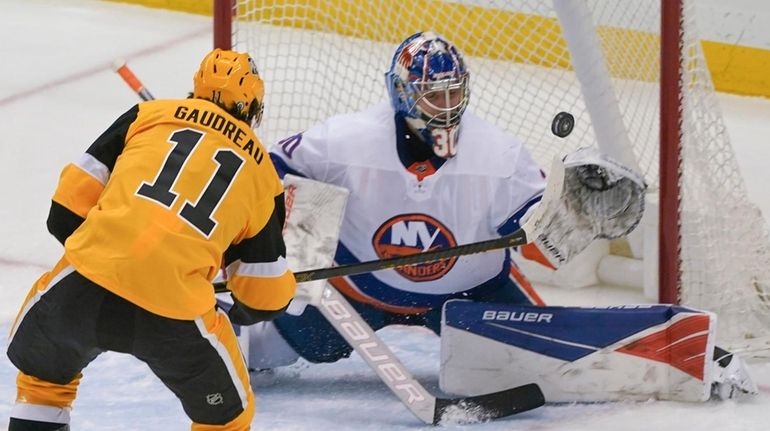 The Penguins' Frederick Gaudreau scores over Islanders goaltender Ilya Sorokin during...