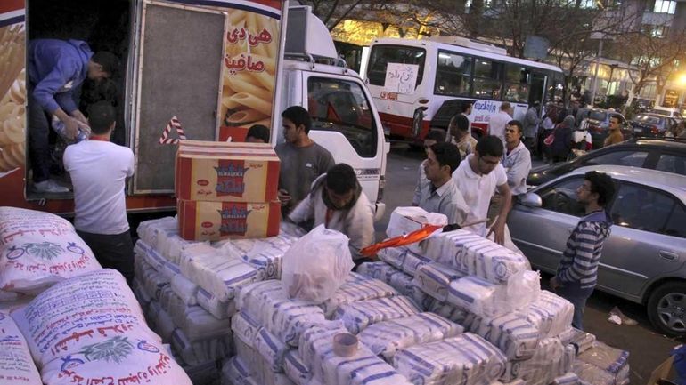 Egyptian volunteers load aid into a truck, as part of...