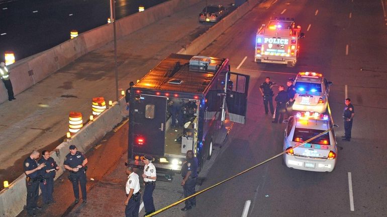 New York Police officers and detectives investigate the scene along...