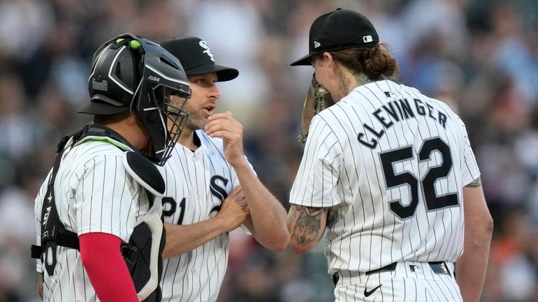 Chicago White Sox pitching coach Ethan Katz, center, talks with...