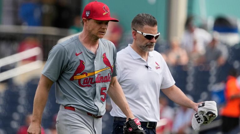 St. Louis Cardinals starting pitcher Sonny Gray, left, walks off...