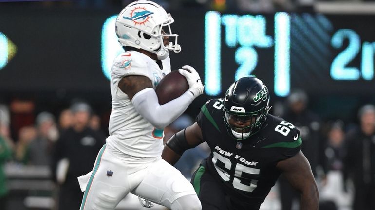 Xavier Newman #65, Jets lineman, right, tries in vain to...