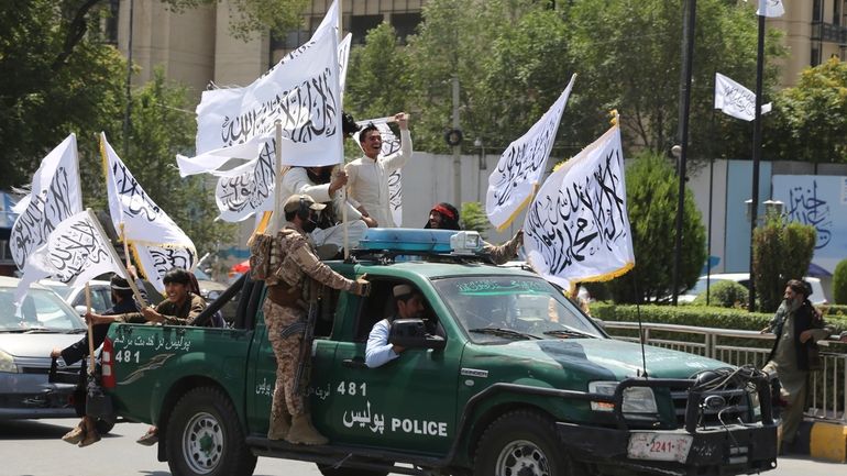 Taliban fighters celebrate the third anniversary of the withdrawal of...