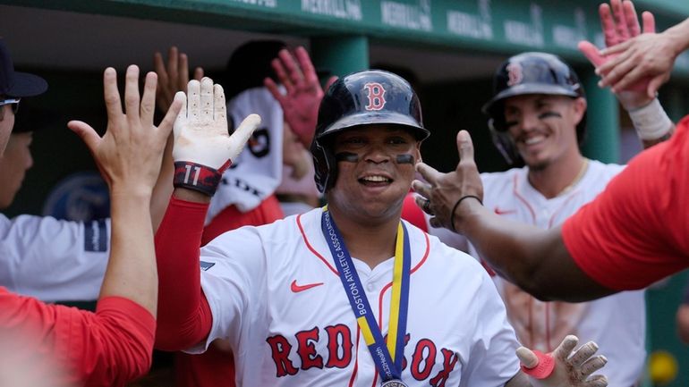 Boston Red Sox's Rafael Devers celebrates in the dugout with...