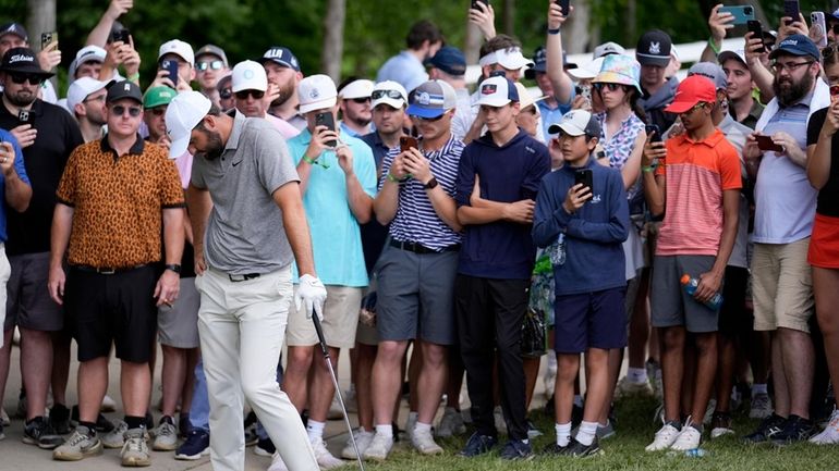 Scottie Scheffler reacts to his chip to the green on...