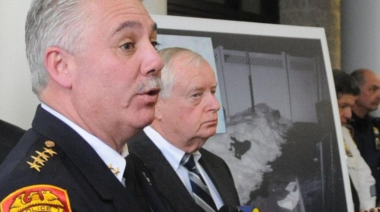 Suffolk County District Attorney Thomas Spota, center, looks on as...