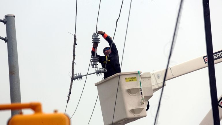 Utility crews work to restore electricity in Houston, July 11,...