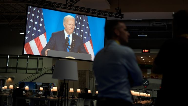 President Joe Biden's news conference is projected onto a screen...