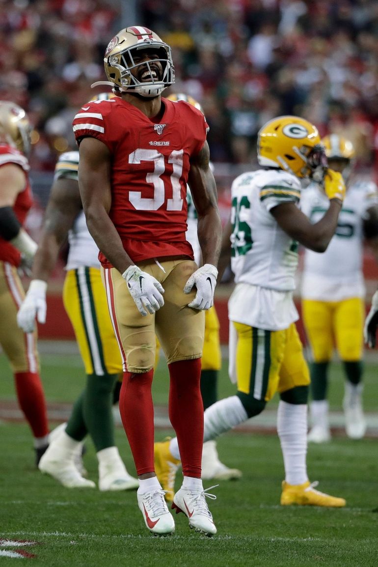 Green Bay Packers running back Aaron Jones (33) runs in front of San  Francisco 49ers cornerback Richard Sherman (25) and strong safety Jaquiski  Tartt (29) during the NFL football NFC Championship game