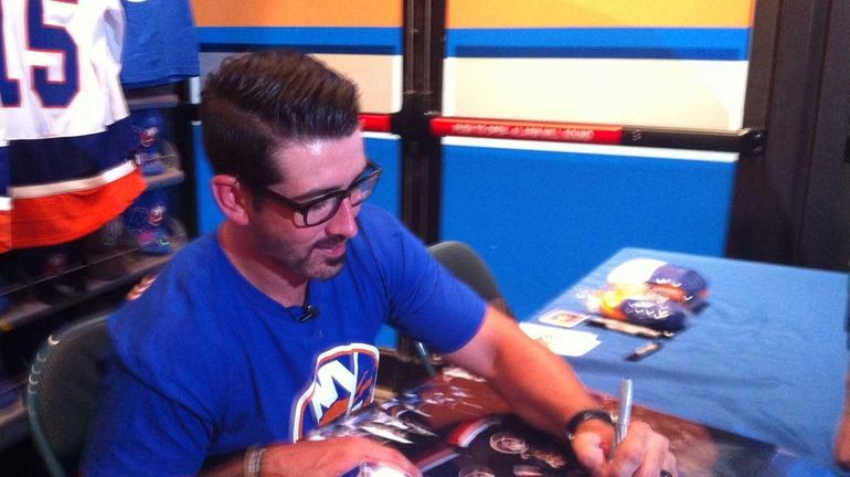 Islanders forward Cal Clutterbuck signs autographs for fans at Nassau...