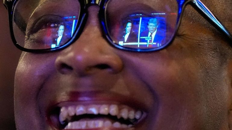 Sheena Carey laughs as she watches the presidential debate between...