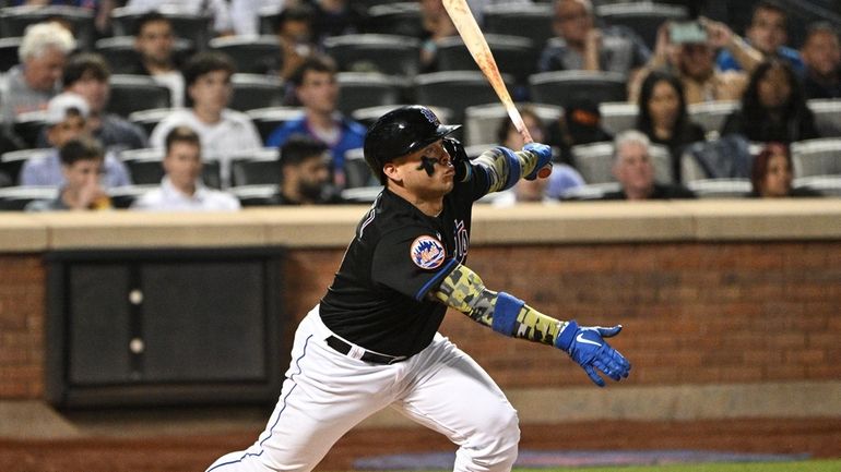 New York Mets' Francisco Alvarez singles against the Cleveland Guardians...