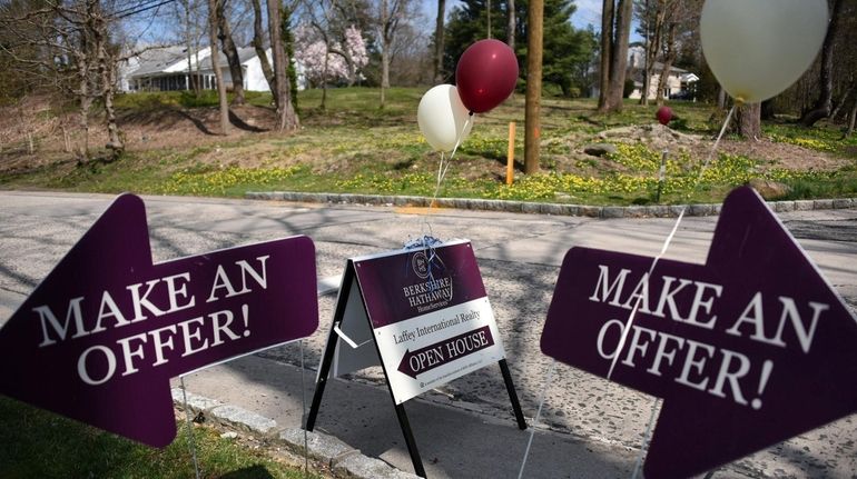 A sign advertising an open house outside 665 Motts Cove...