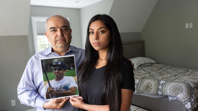 Kamal Bherwani and his daughter, Ava, 24, hold a picture of...