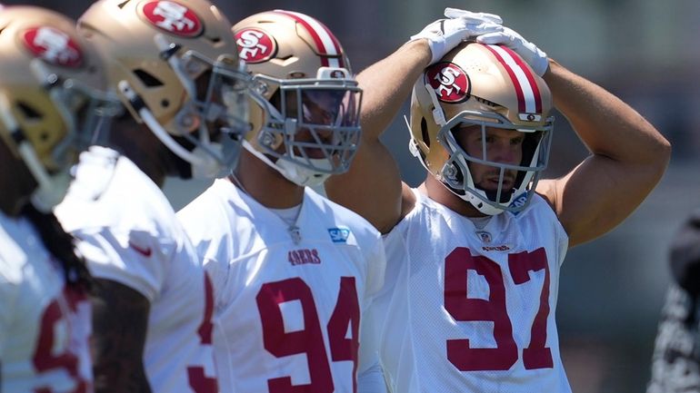 San Francisco 49ers' Yetur Gross-Matos (94), Nick Bosa (97) and...