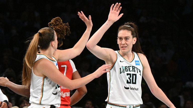 Liberty forward Breanna Stewart and guard Sabrina Ionescu react during...